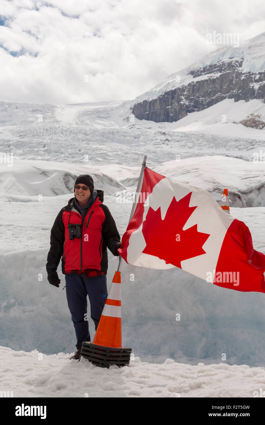 Touristischen posiert mit der kanadischen Flagge am Athabasca Gletscher in den Rocky Mountains, Alberta, Kanada, Nordamerika. Stockfoto