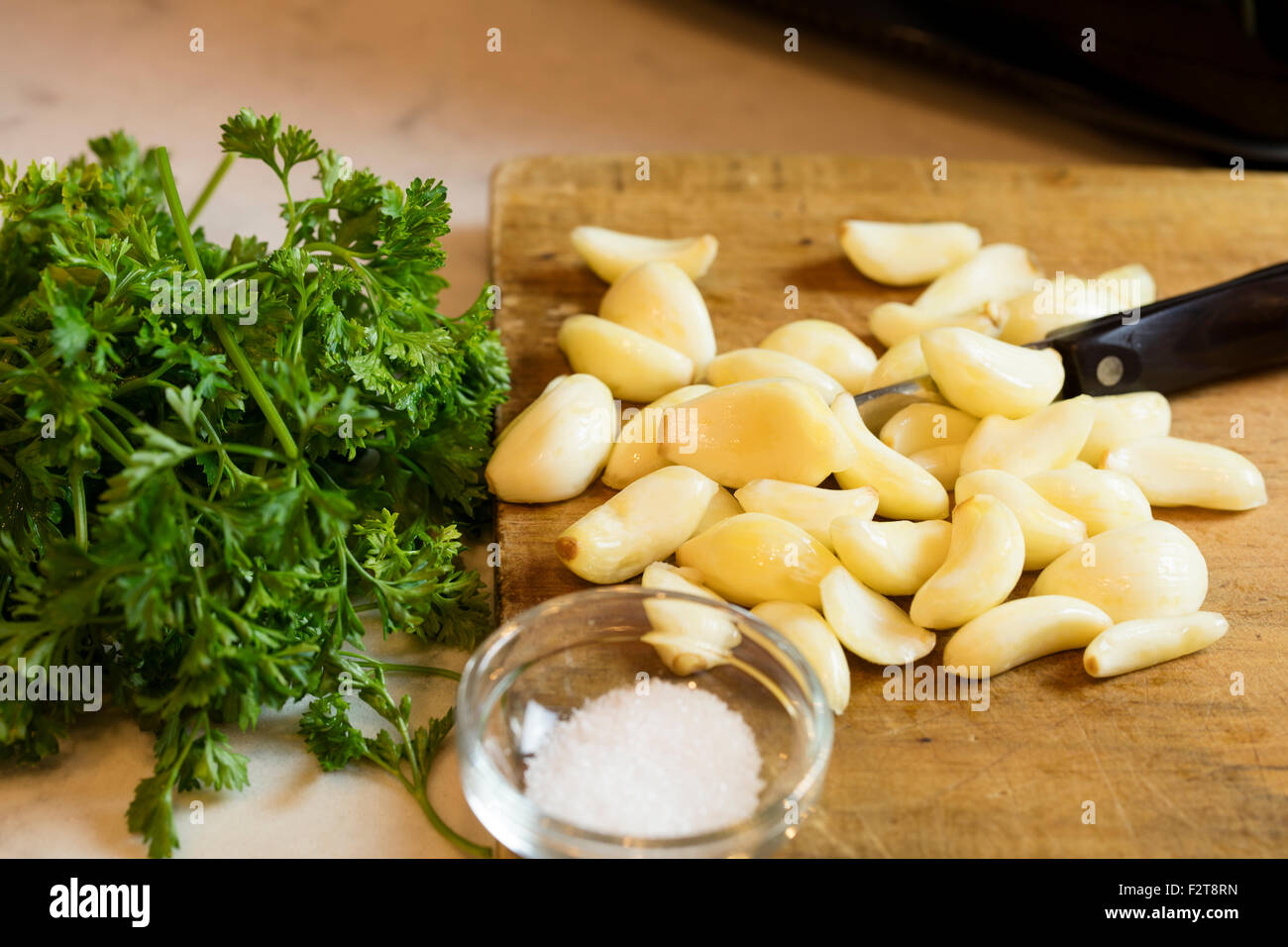 Bereit, Knoblauch und Petersilie hacken als Beilage zu einer Mahlzeit Stockfoto