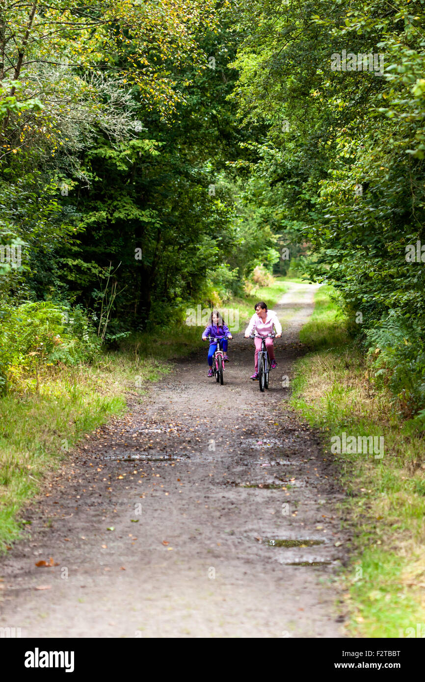 2 junge Mädchen Fahrrad entlang einer alten Bahn verfolgen mittlerweile zu einem Radweg umgebaut Stockfoto