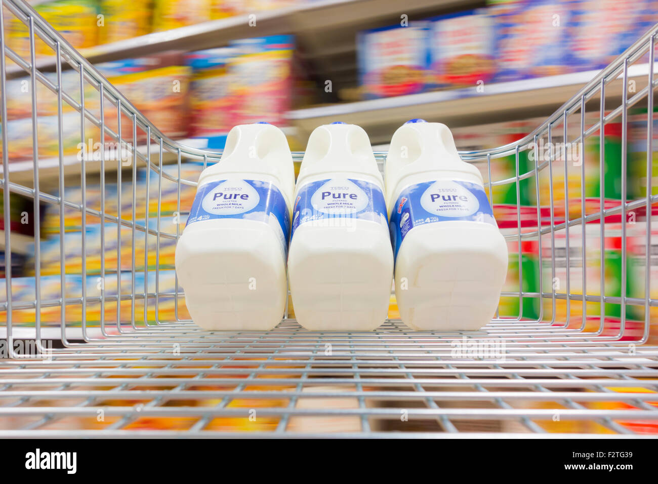 Milch im Einkaufswagen im Supermarkt Tesco. UK Stockfoto