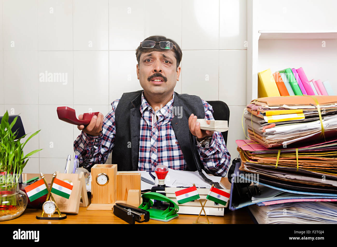 1 indischer Mann Regierungsmitarbeiter Büro sitzen arbeiten Problem Telefon sprechen Stockfoto