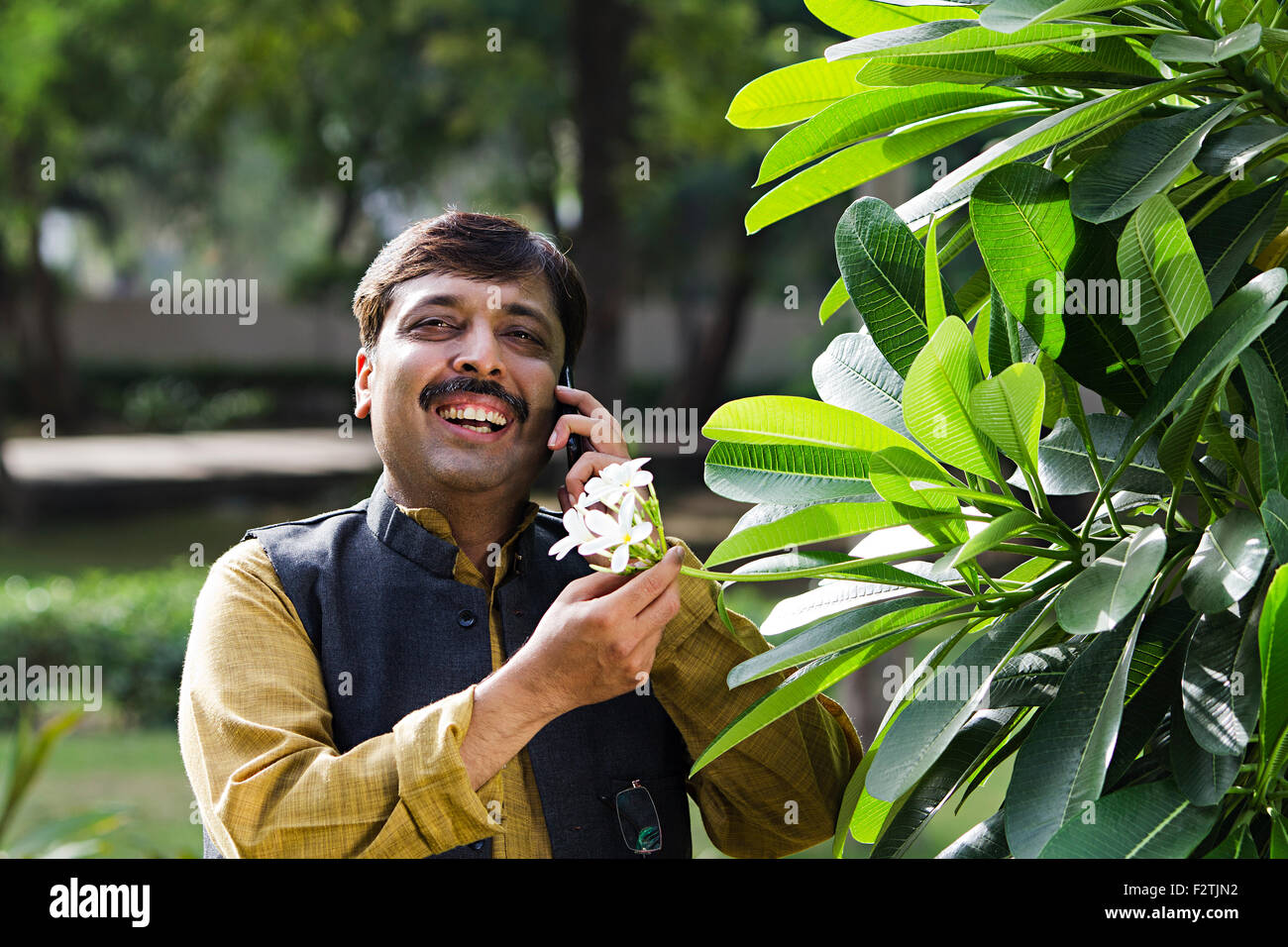 1 indische erwachsenen Mann Garten stehend reden Handy Stockfoto