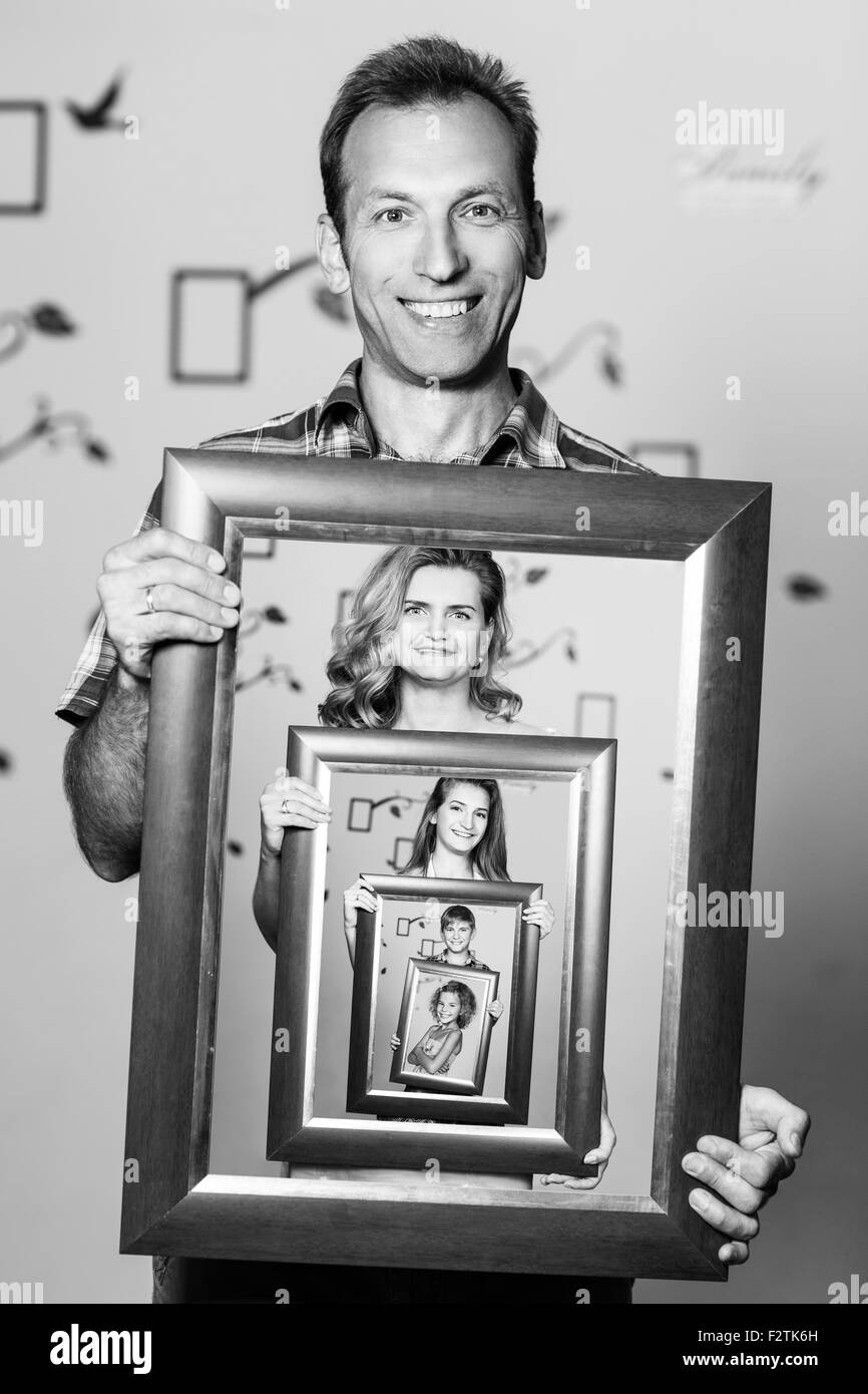 Glücklicher Vater hält Porträt mit seiner Familie Stockfoto