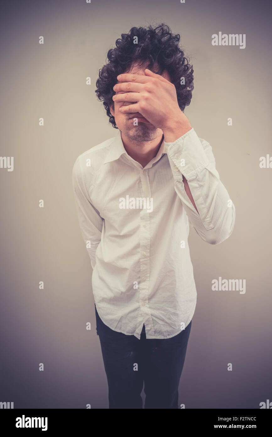 Junger Mann ist Gesicht palming Stockfoto