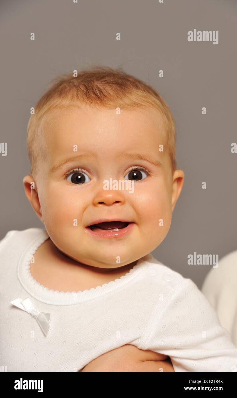 Entzückende Baby auf grauem Hintergrund isoliert Stockfoto