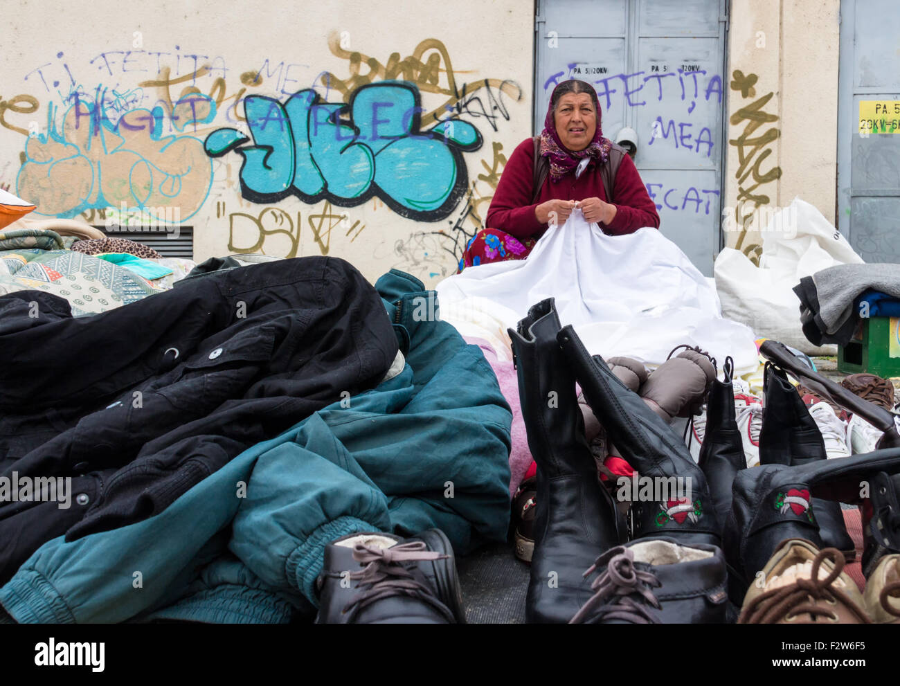 TARGU-MURES, Landkreis MURES, Rumänien - 19. Oktober 2014: Eine Frau mittleren Alters Gipsy ist gebrauchte Kleidung, Schuhe und Stiefel zu verkaufen Stockfoto