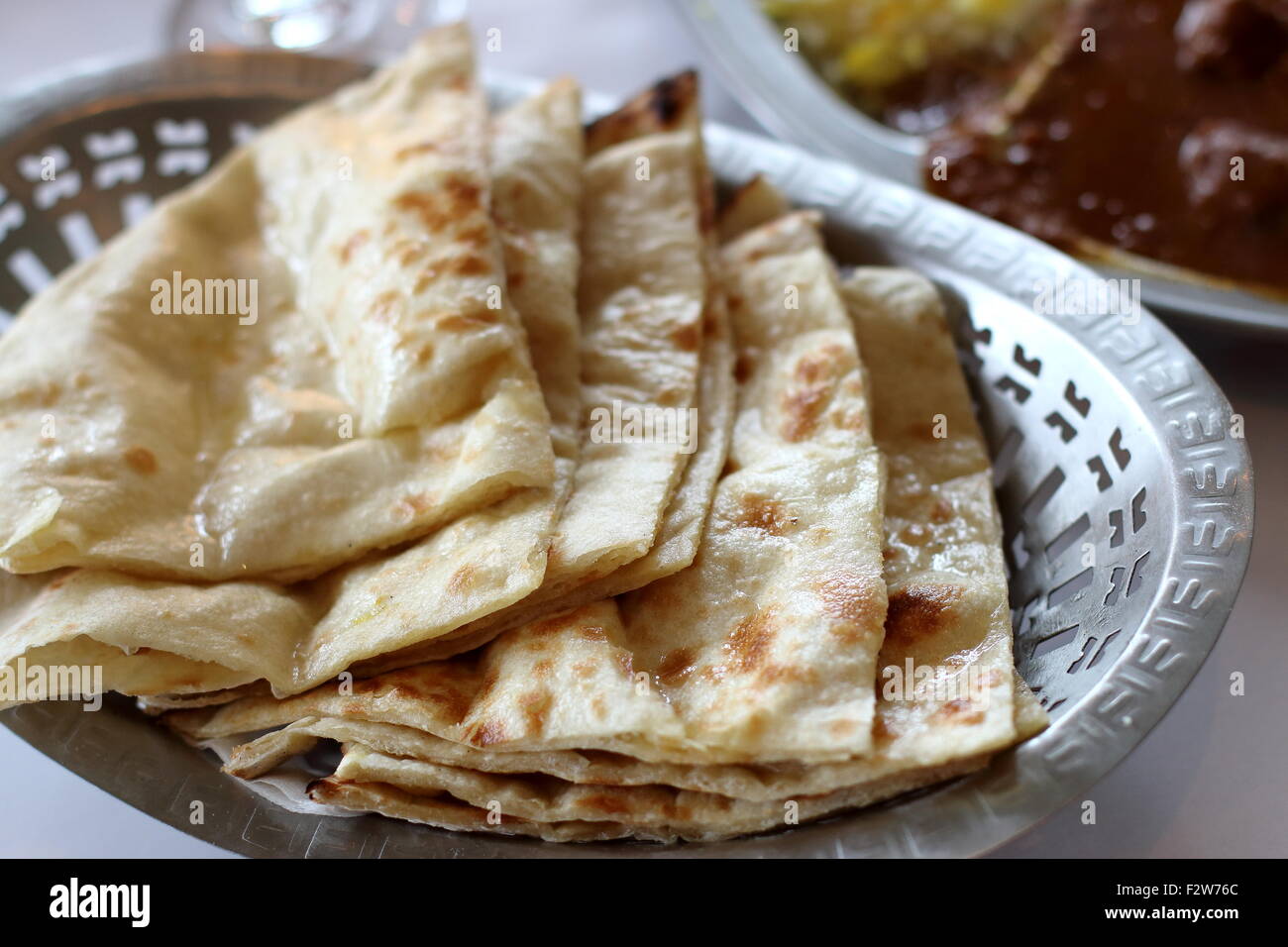 Nahaufnahme von frisch zubereitetes Naan Brot in eine Schüssel geben Stockfoto