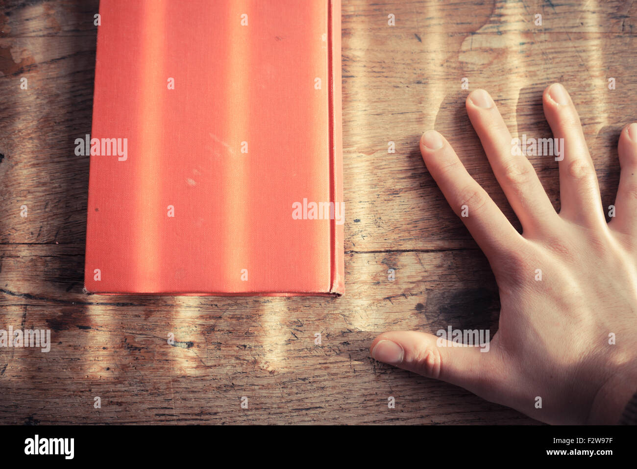 Hand und auf einem Tisch mit Schatten von Jalousien Stockfoto