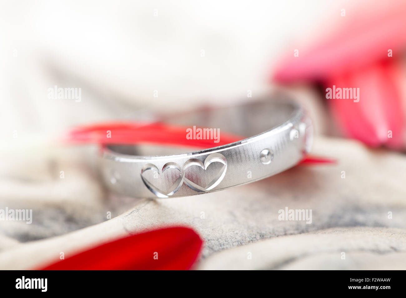 Silberring mit graviertem Herz und Blütenblättern. Stockfoto