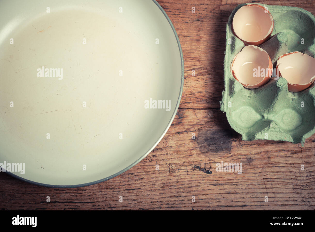 Pfanne und Eiern auf einem Holztisch Stockfoto