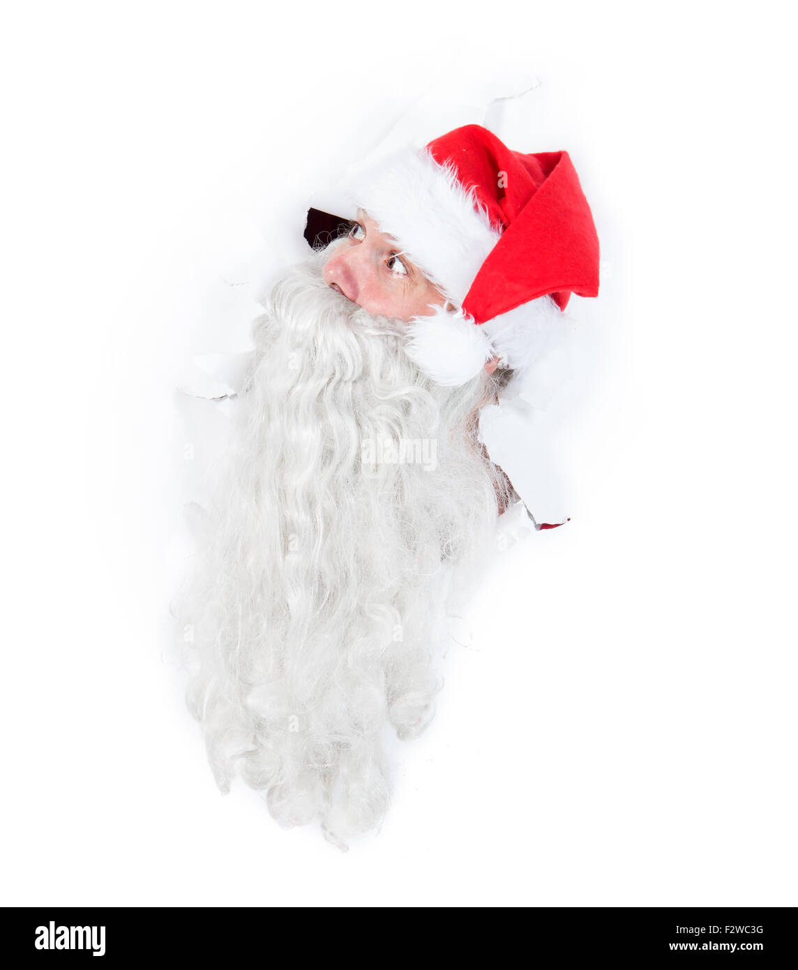 Santa Claus durch Loch in einer weißen Wand Stockfoto