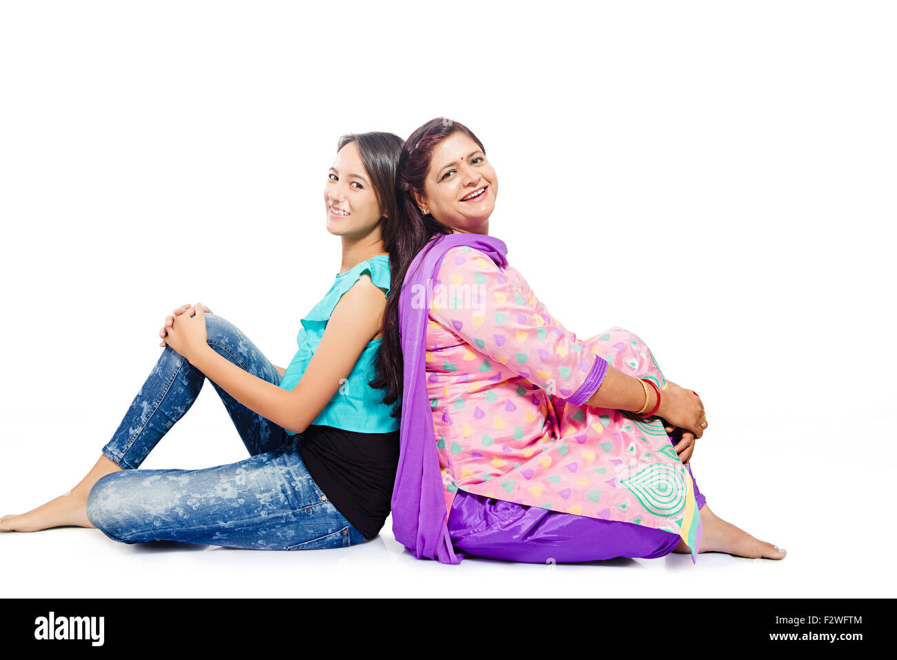 2 indische Mutter und Tochter sitzen Rücken an Rücken Stockfoto