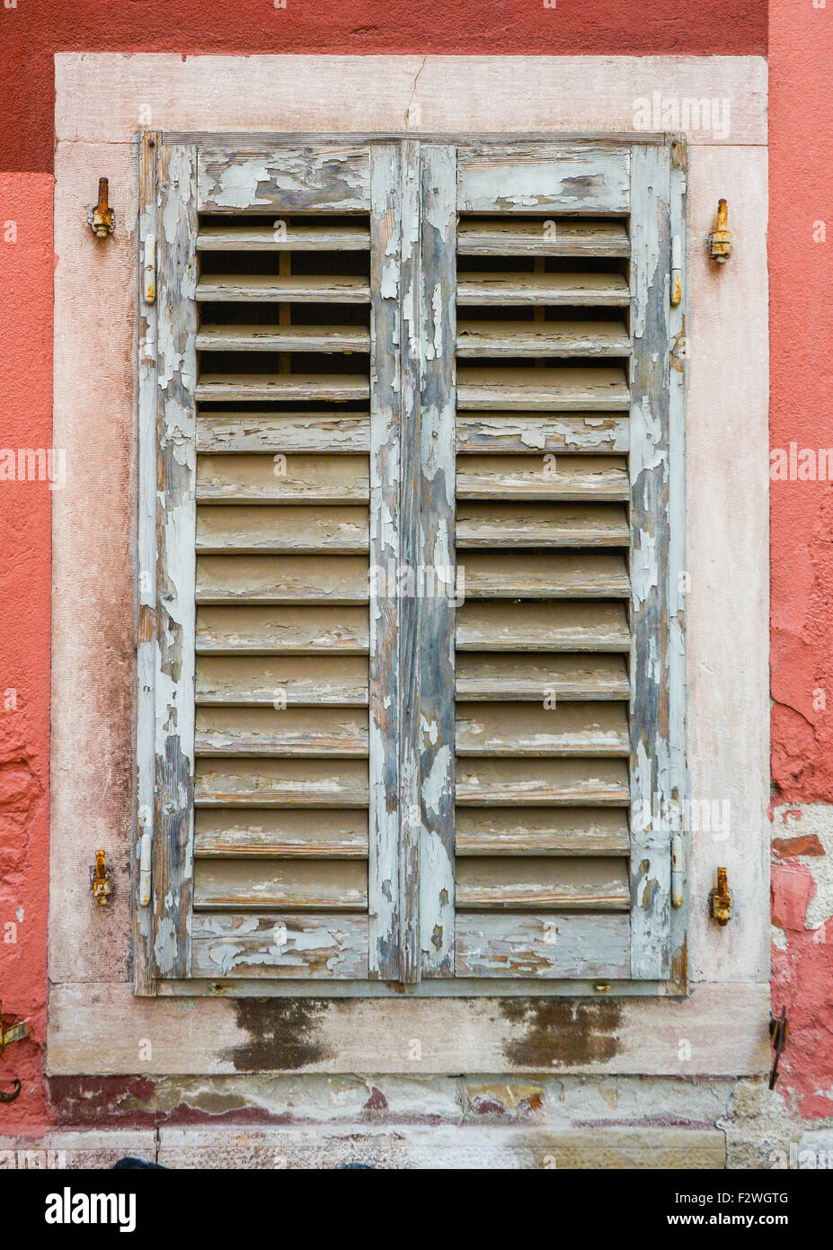 alte Fenster mit geschlossenen grauen Fensterläden aus Holz Stockfoto