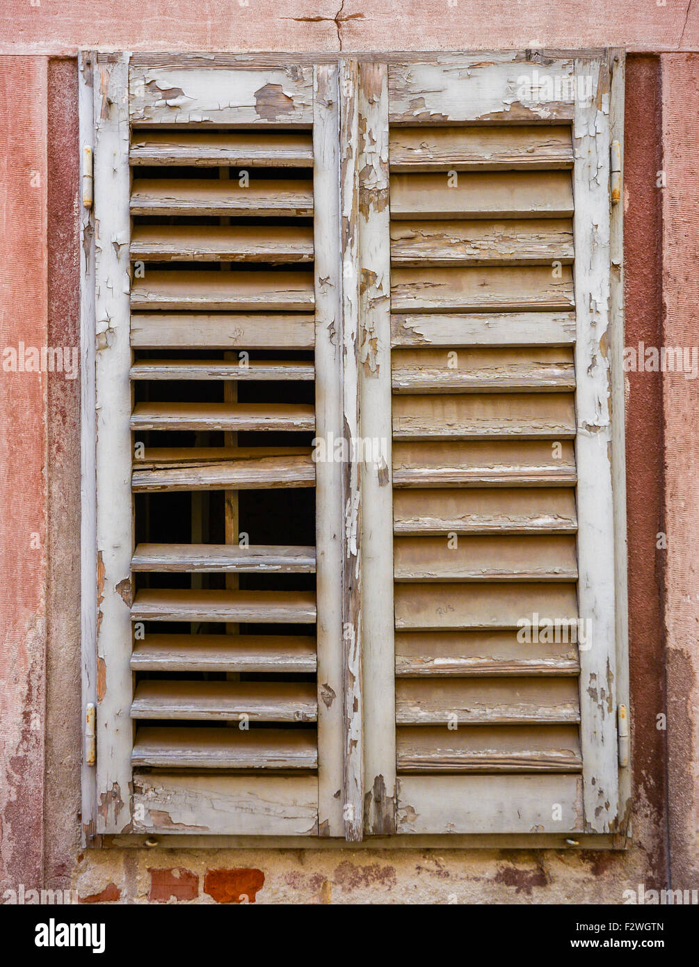 alte Fenster mit geschlossenen grauen Fensterläden aus Holz Stockfoto