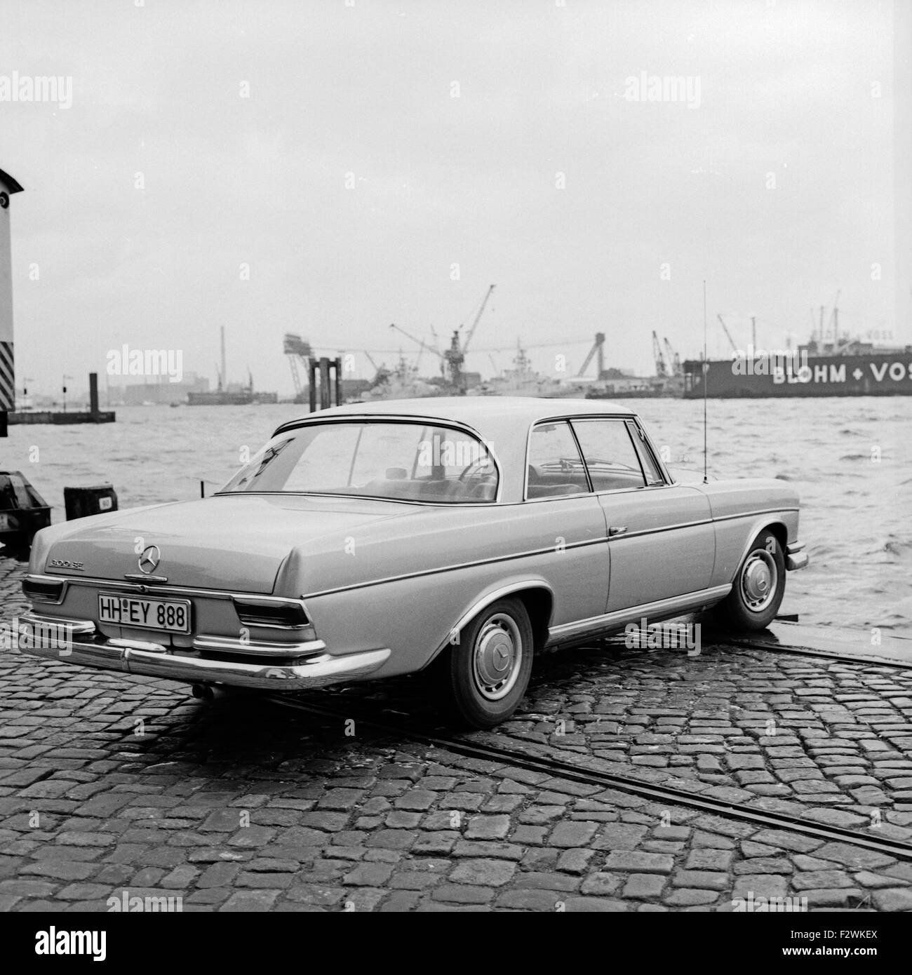 Ein Mercedes-Benz 300 SE Coupé bin Hafen in Hamburg, Deutschland, 1960er Jahre. Ein Mercedes Benz 300 SE Coupé im Hamburger Hafen, Deutschland der 1960er Jahre. Stockfoto