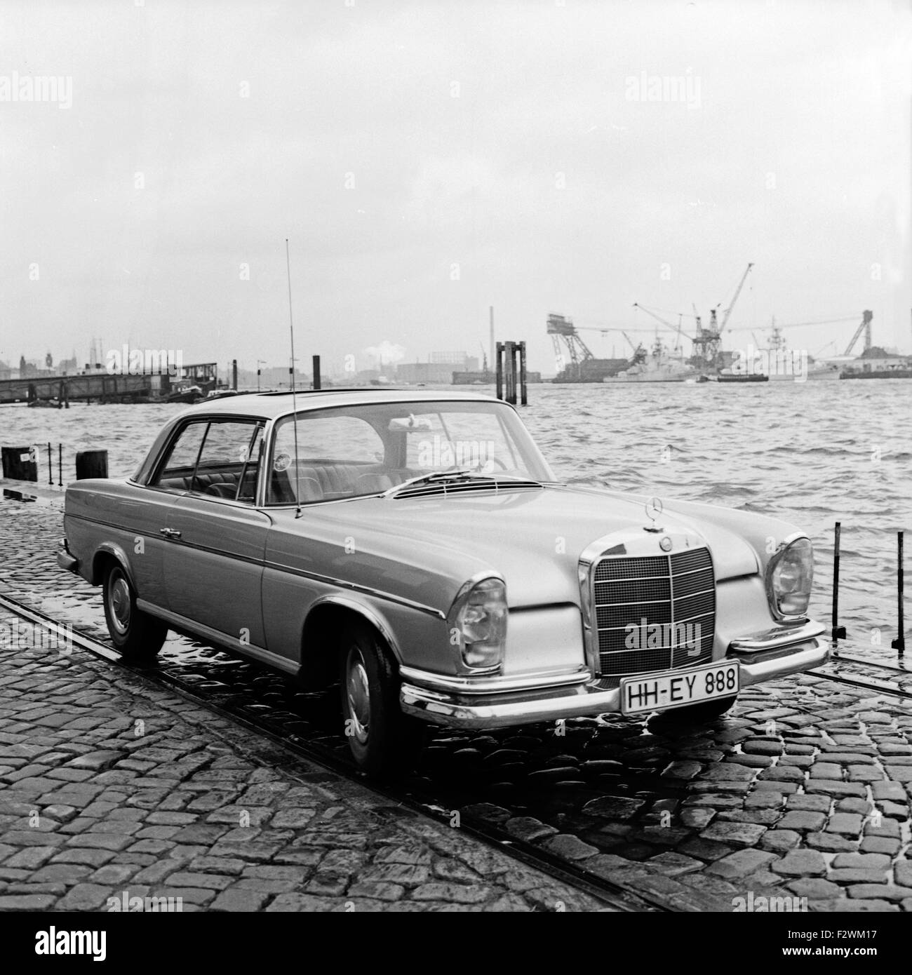 Ein Mercedes-Benz 300 SE Coupé bin Hafen in Hamburg, Deutschland, 1960er Jahre. Ein Mercedes Benz 300 SE Coupé im Hamburger Hafen, Deutschland der 1960er Jahre. Stockfoto