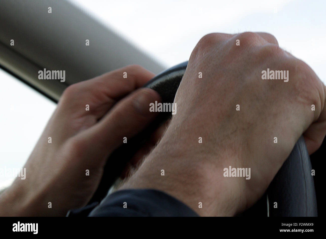 Fahren Sie vorsichtig mit beiden Händen am Lenkrad Stockfoto