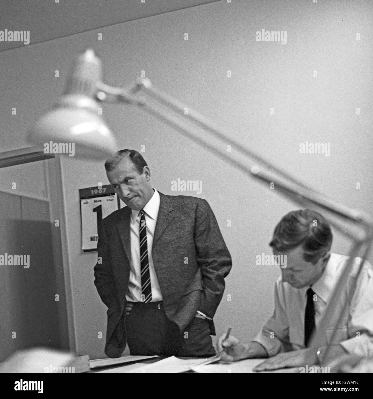 Deutscher Nachrichtensprecher Karl Heinz Köpcke in der Redaktion der "Tagesschau" beim NDR in Hamburg, Deutschland 1960er Jahre. German News Moderator Karl Heinz Koepcke an Editor's Office der Nachrichten anzeigen 'Tagesschau' am Gebäude des Norddeutschen Rundfunks TV und Radio Station in Hamburg, Deutschland 1960. Stockfoto