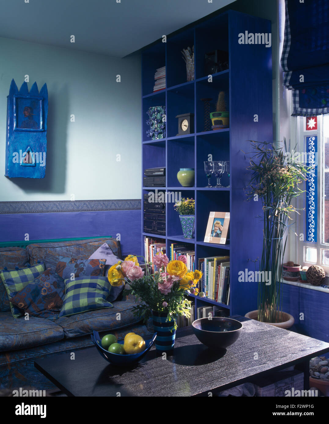 Kleine blau bemalte Wandschrank und leuchtend blaue Cube Regale in hell blau Wohnzimmer der neunziger Jahre Stockfoto