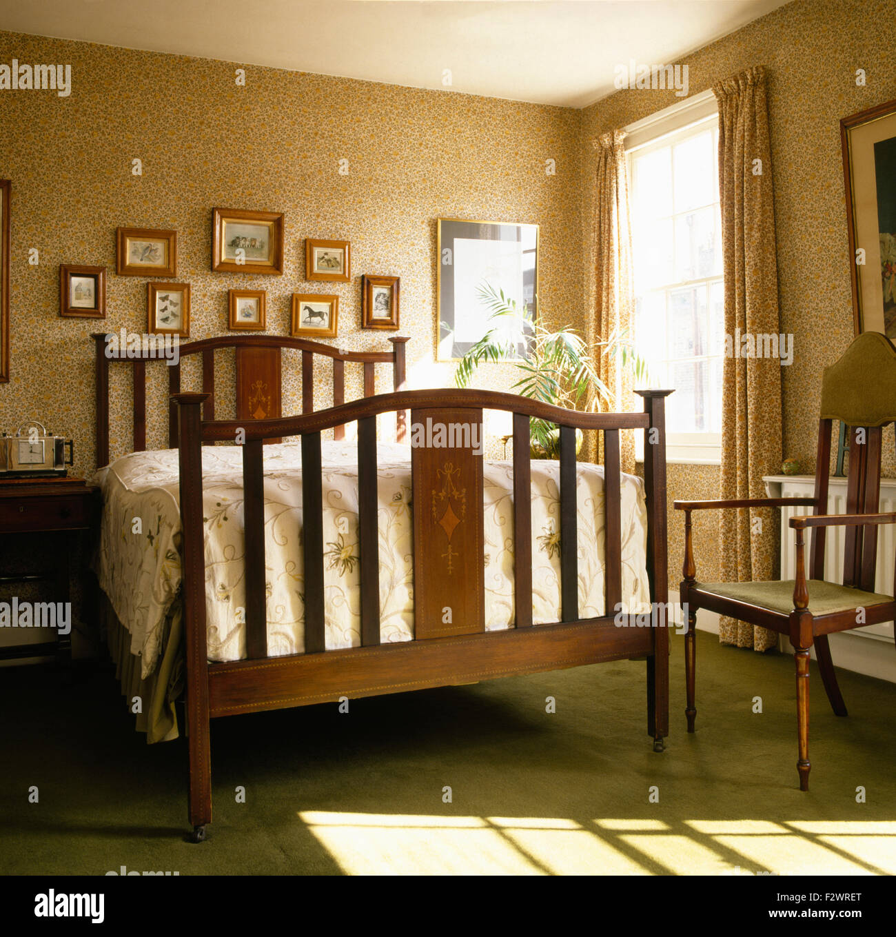 Mustertapeten und einfachen Holzbett in vierziger Jahre Stil Schlafzimmer Stockfoto