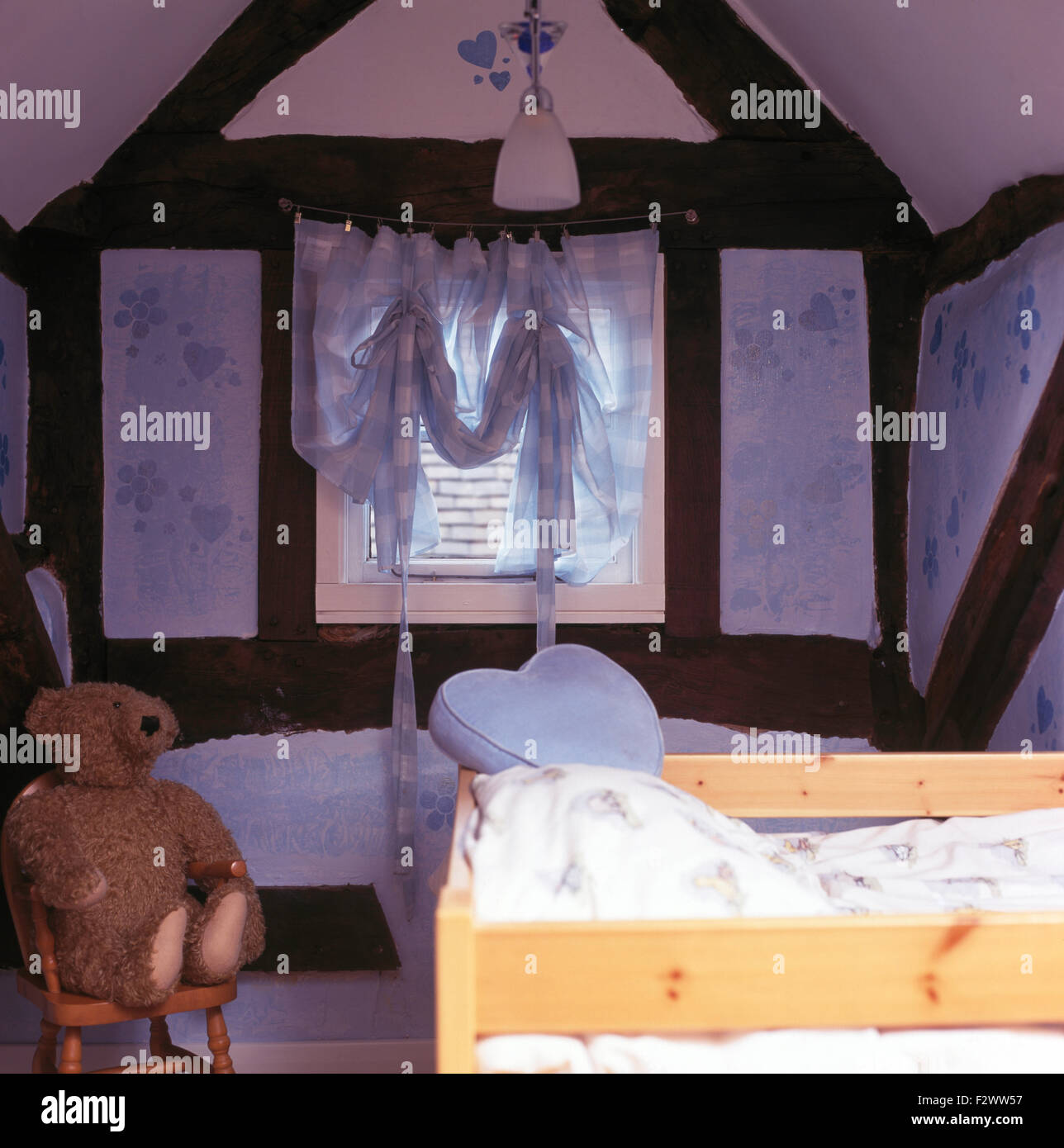 Chid Voile Schwalbenschwanz blind am Fenster in der neunziger Jahre strahlte Mansarde mit einem einfachen Holzbett Stockfoto