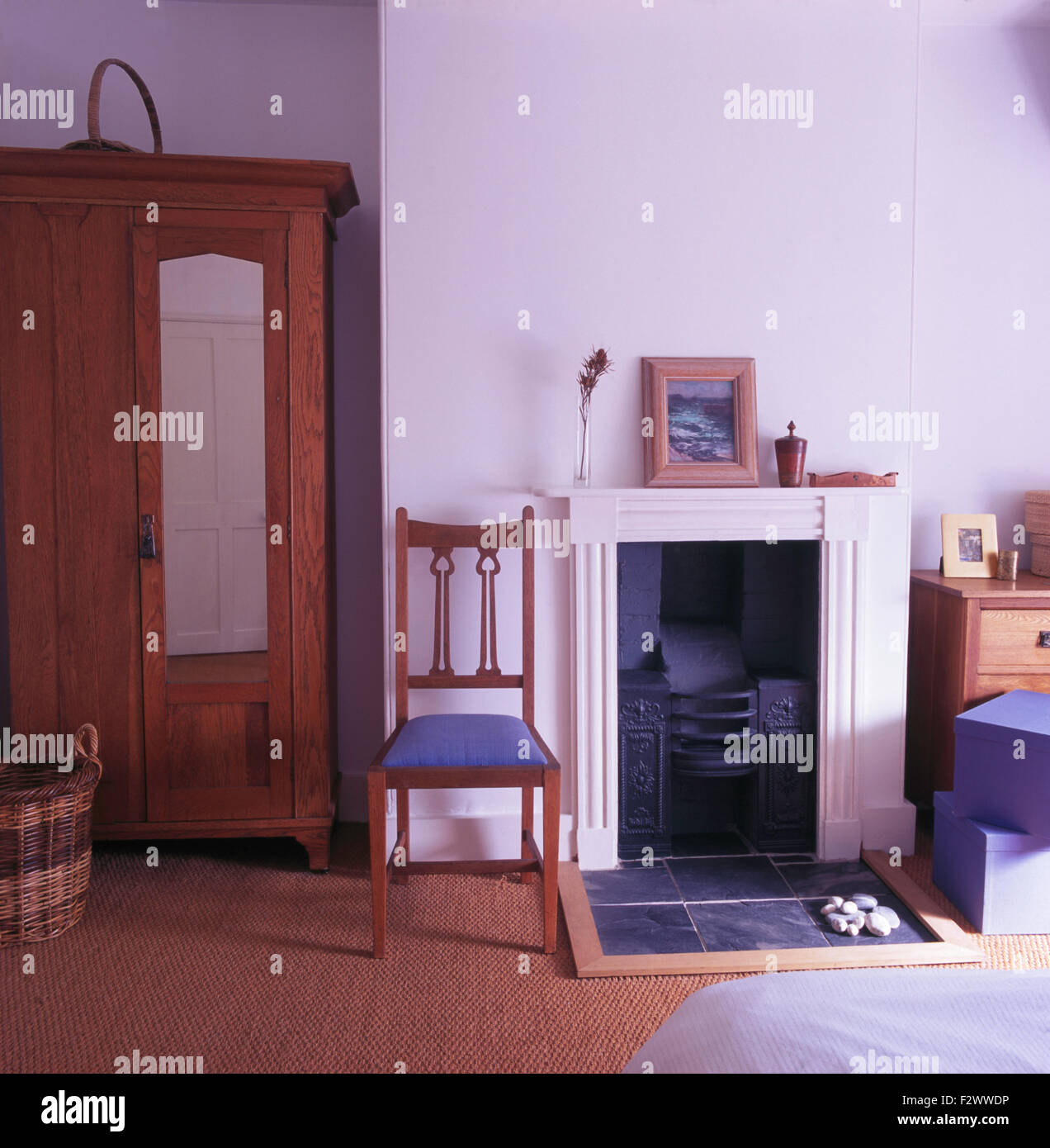 Kunst + Handwerk Kleiderschrank im Schlafzimmer Stadthaus mit eleganter Stuhl neben dem Kamin Stockfoto