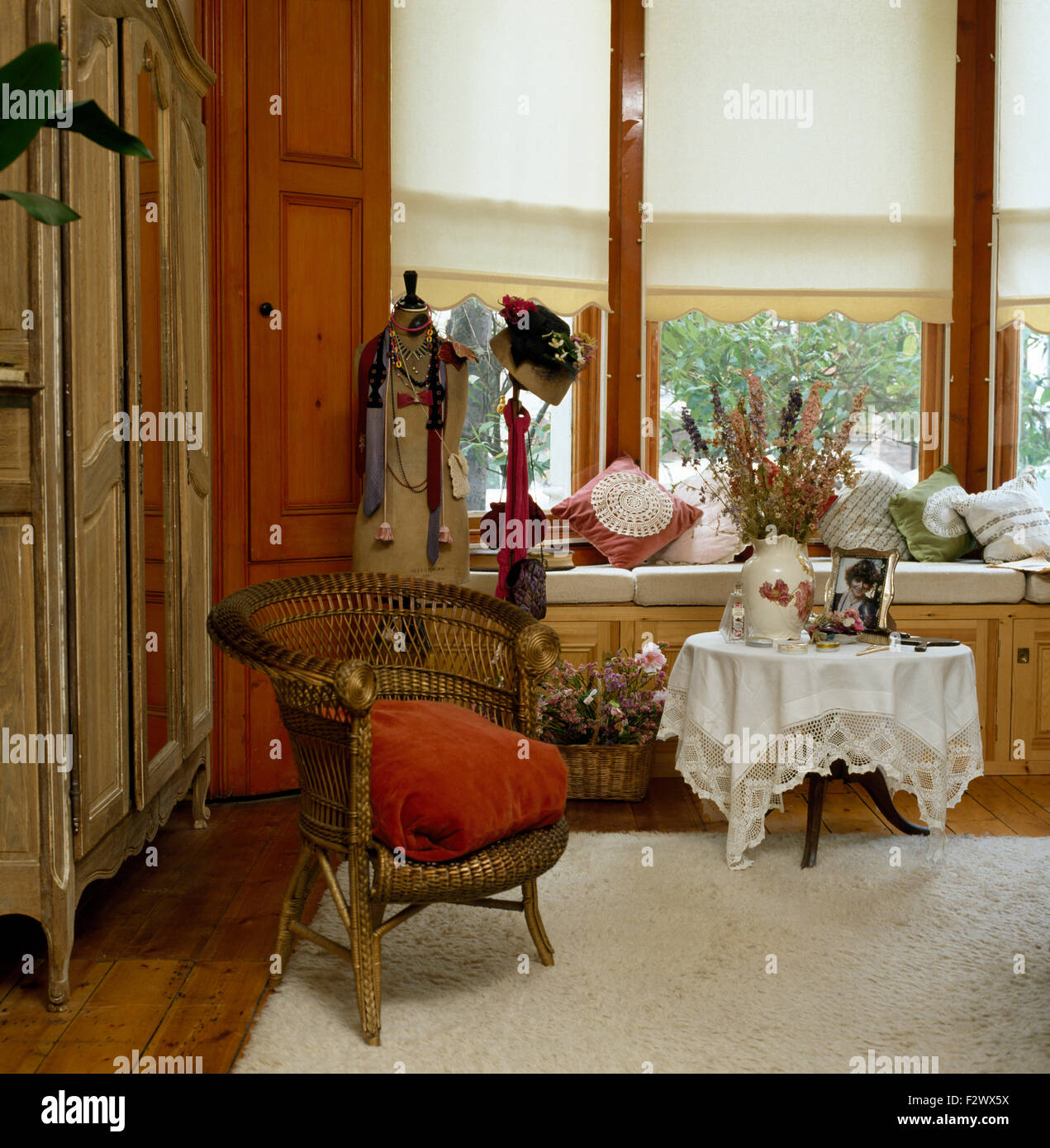 Gold lackiert Korbstuhl in achtziger Jahre Schlafzimmer mit weißen Vorhänge am Fenster Stockfoto