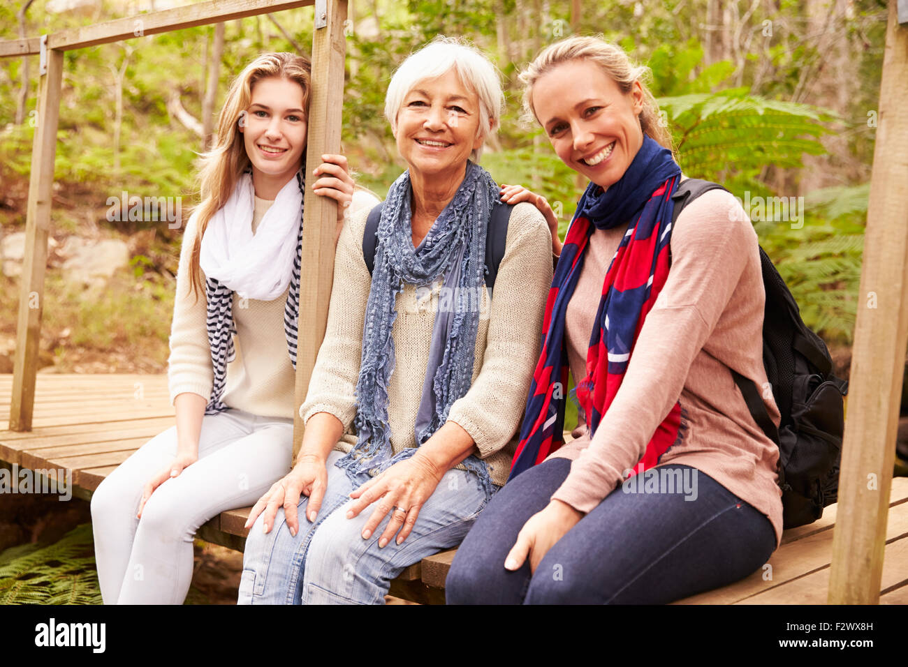 Drei Generationen von Frauen sitzen in einem Wald, Porträt Stockfoto