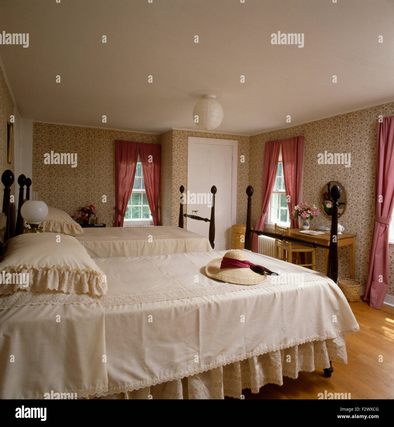 Spitze Kanten Bettdecke auf zwei Einzelbetten mit gedrehten Spindeln in neunziger Jahre Schlafzimmer Stockfoto