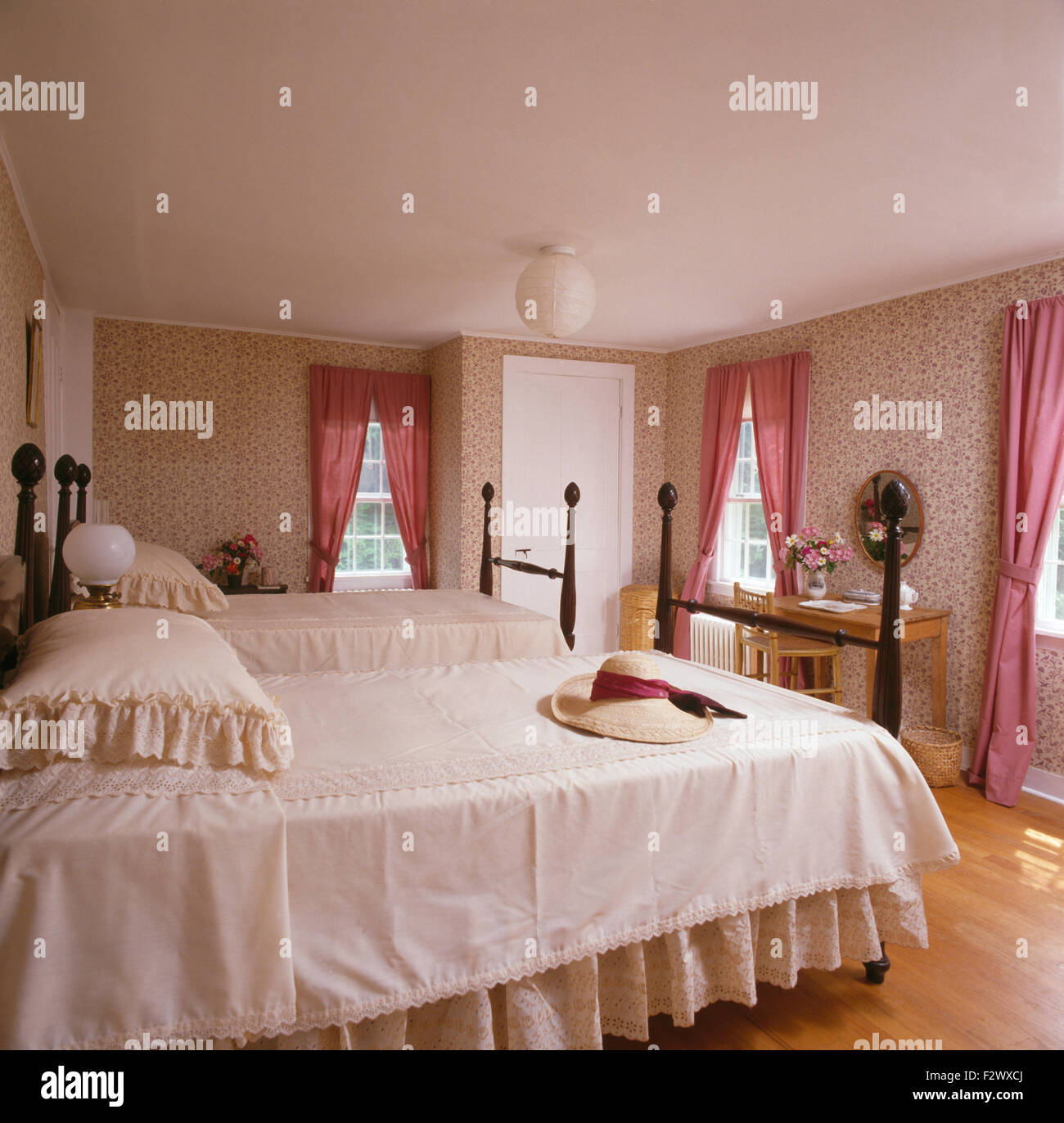 Spitze Kanten Bettdecke auf zwei Einzelbetten mit gedrehten Spindeln in neunziger Jahre Schlafzimmer Stockfoto