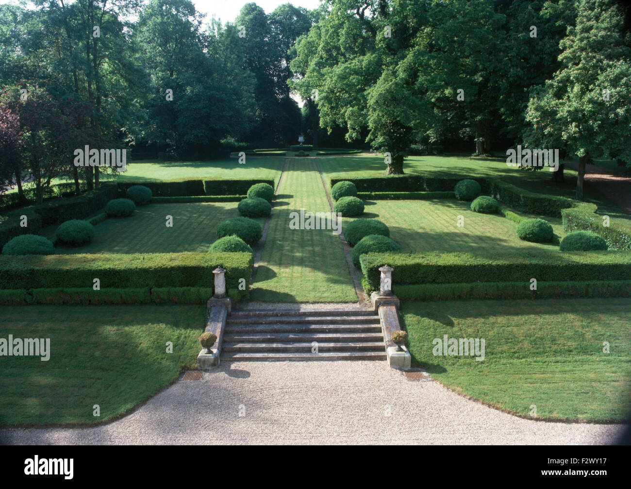 Steinstufen zu Rasen Weg durch Wiesen mit beschnittenen Box im großen Bauerngarten mit altem Baumbestand Stockfoto