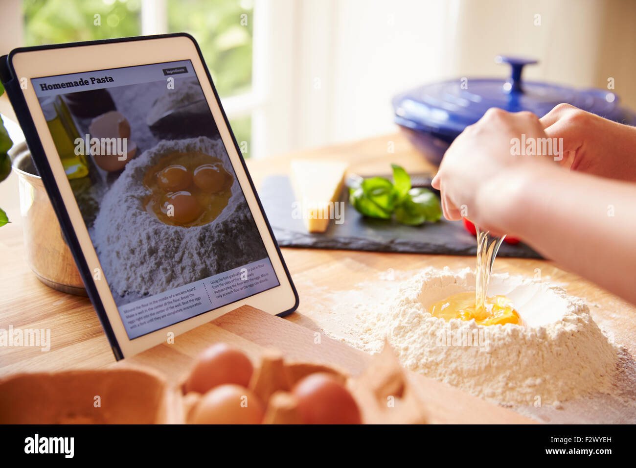 Person nach Pasta Rezept mit App auf Digital-Tablette Stockfoto