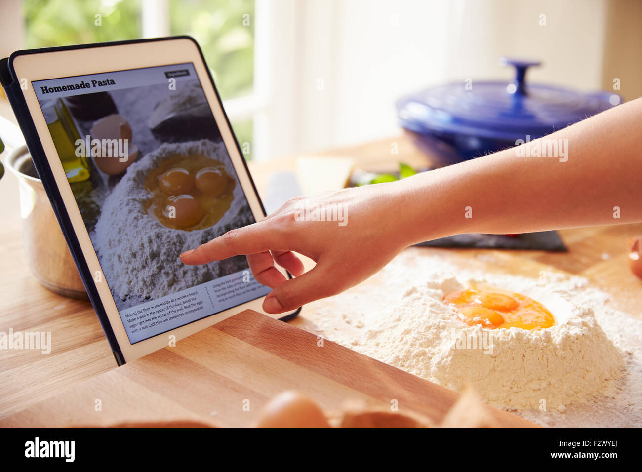 Person nach Pasta Rezept mit App auf Digital-Tablette Stockfoto