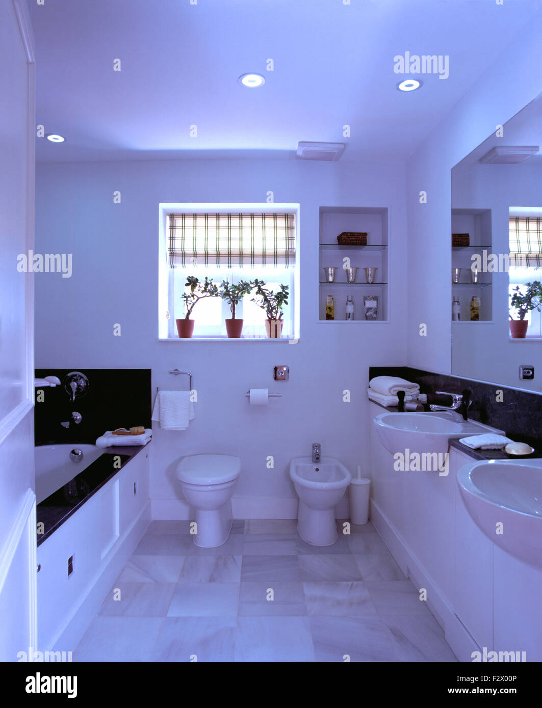 Blinde Fenster über dem WC und Bidet in modernen weißen spanischen Badezimmer mit Doppel-Waschbecken geprüft Stockfoto