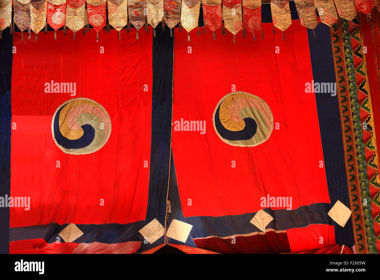 Roter Vorhang mit buddhistisches Symbol, den Hub ein Dharmachakra Rad des Gesetzes darstellt. Tashilhunpo-Heap der Herrlichkeit Monast.-Shigatse Stockfoto