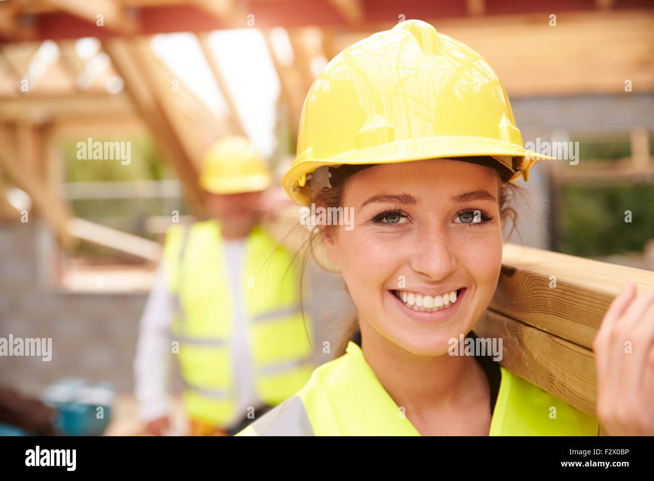Baumeister und weiblichen Lehrling trägt Holz vor Ort Stockfoto