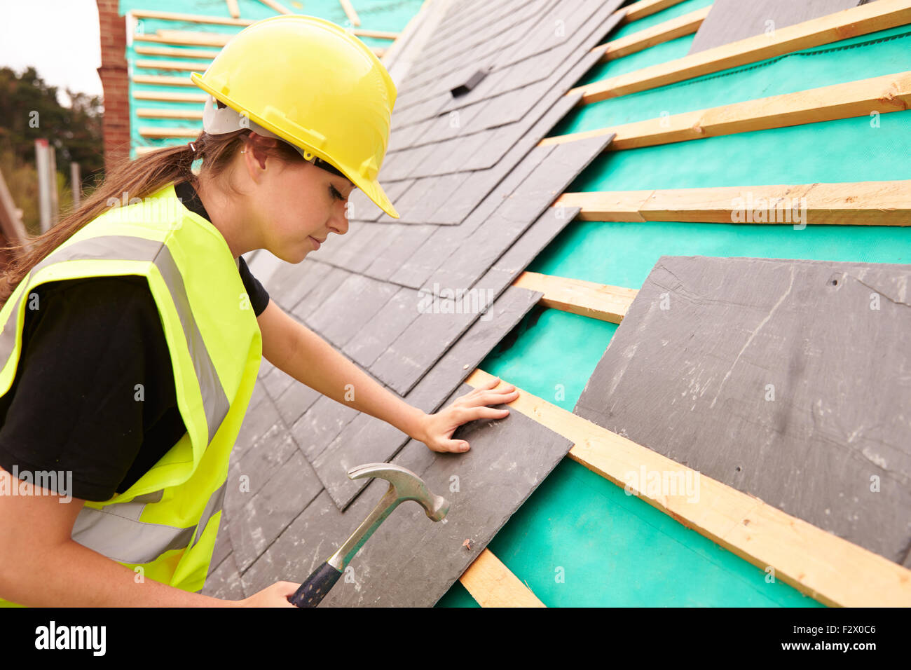 Weibliche Bauarbeiter vor Ort Schiefer Fliesen Stockfoto