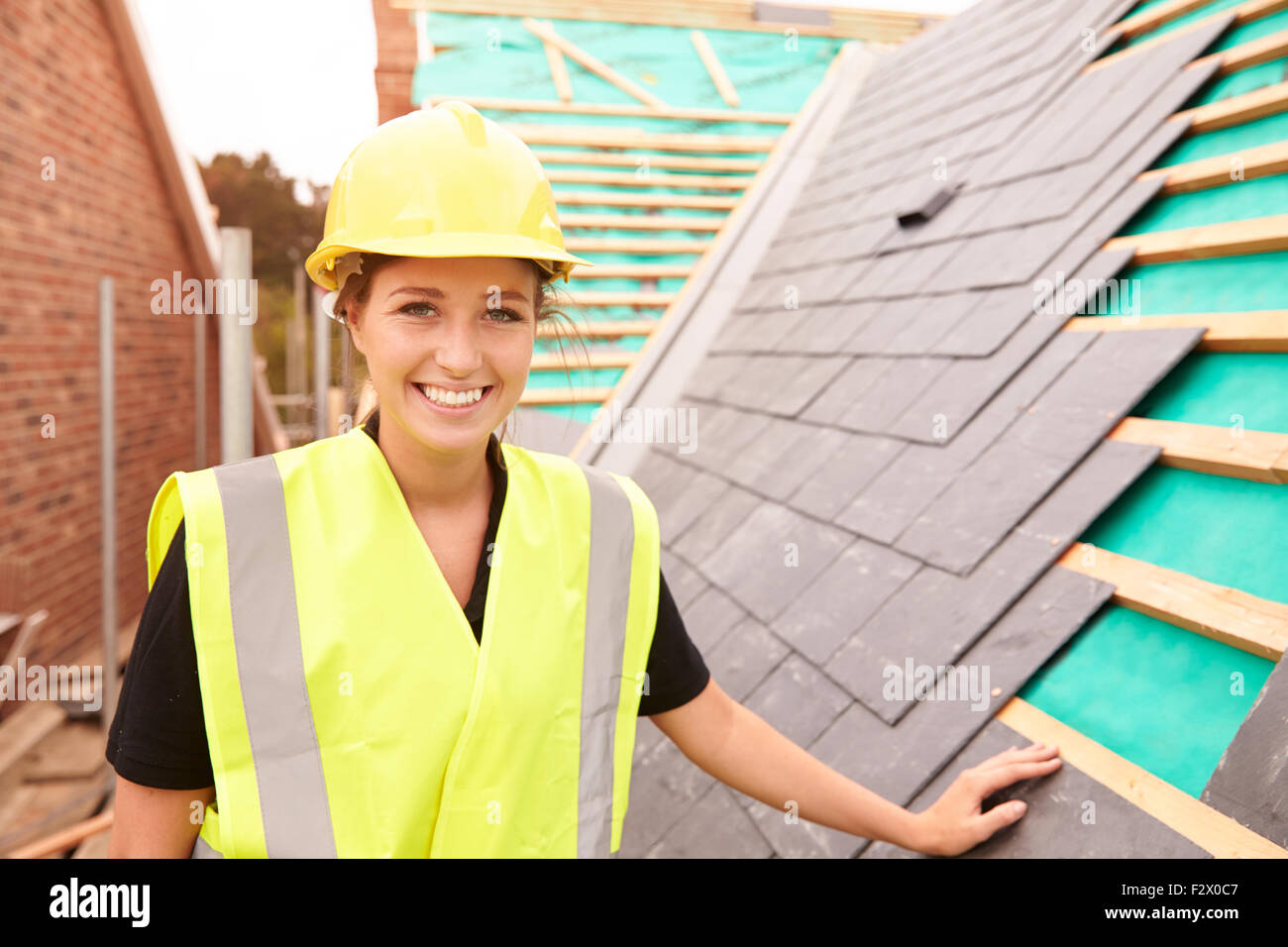 Weibliche Bauarbeiter vor Ort Schiefer Fliesen Stockfoto