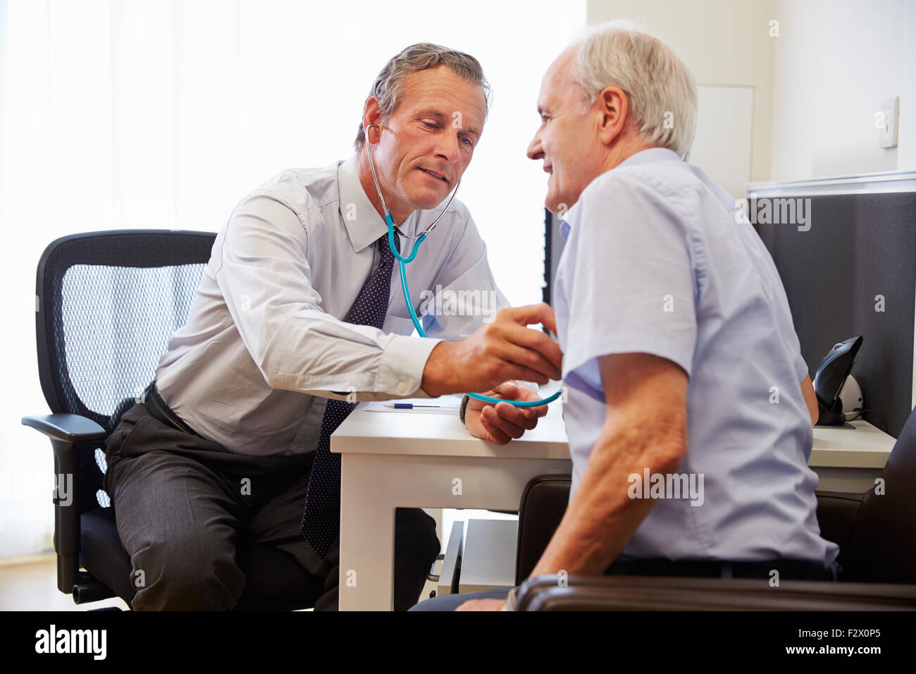 Ältere Patienten mit ärztliche Untersuchung mit Arzt In Büro Stockfoto