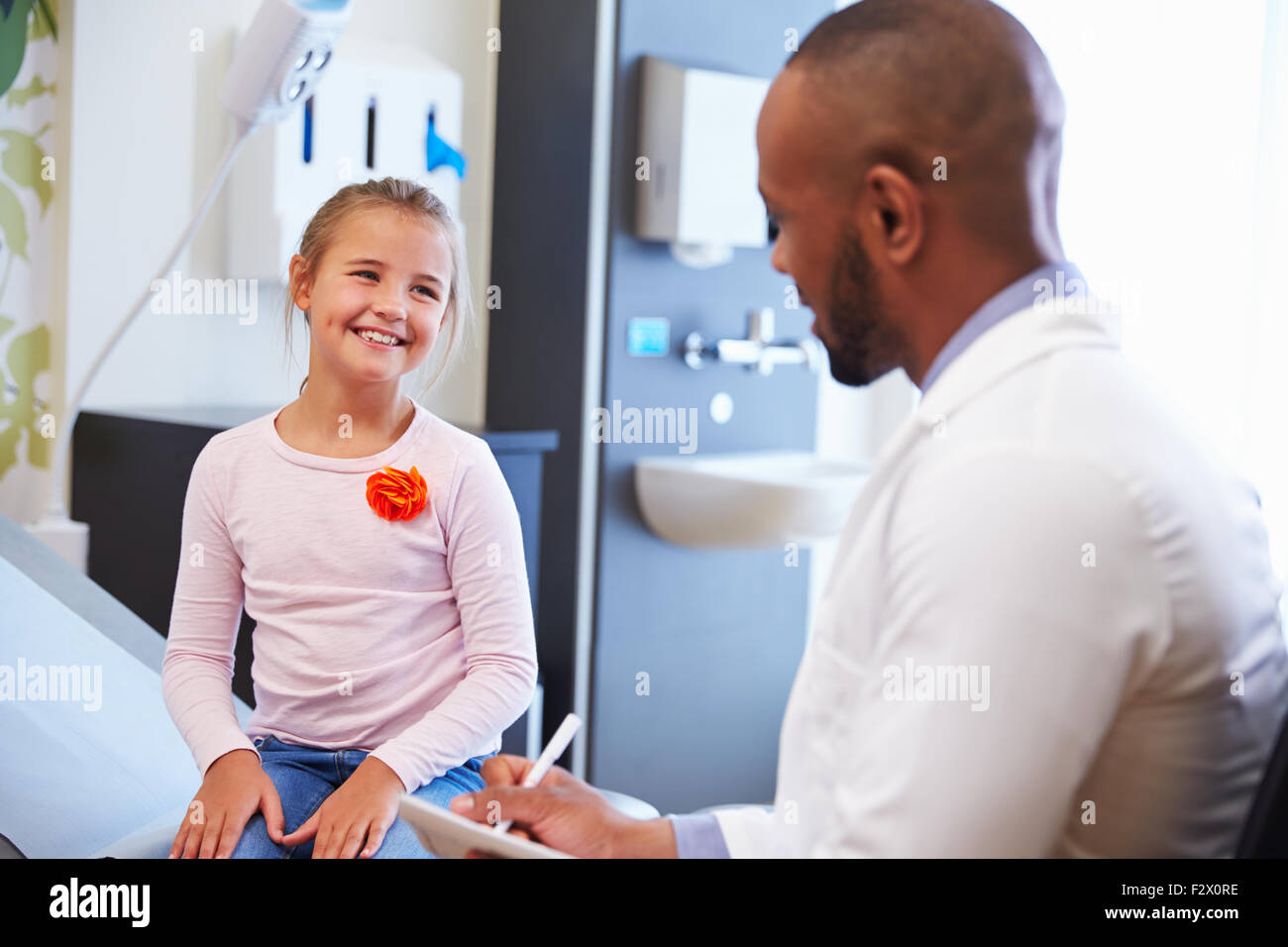 Mädchen im Gespräch mit Arzt im Krankenzimmer Stockfoto