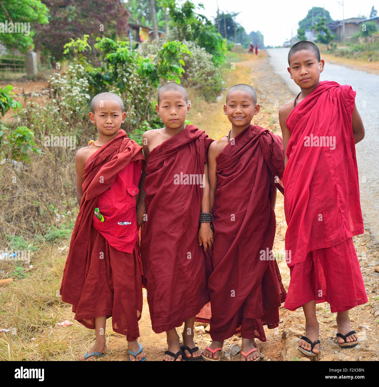 Vier junge Theravada-buddhistischen Mönche tragen ihre Kleider auf der Straße in Myanmar (Burma, Birma) Asia Stockfoto