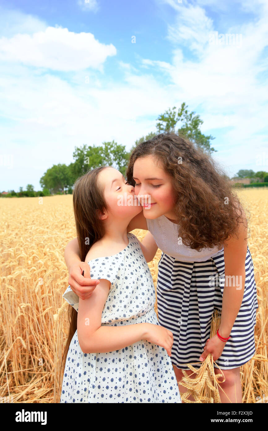 Glückliche Momente mit der Familie - junge Mädchen, die Spaß ln Weizenfeld Stockfoto