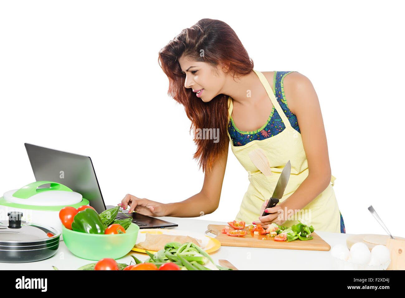 1 indische erwachsenen Frau Hausfrau Küche kochen und Laptop Multitasking Stockfoto