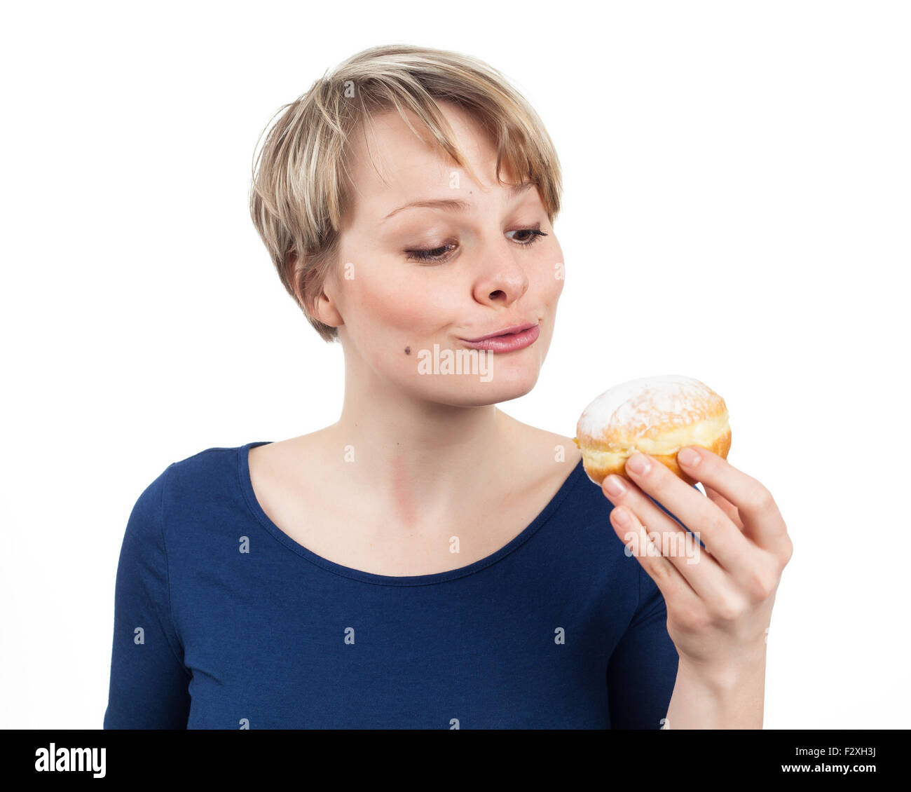 Lustige junge Frau über das Essen eines Donuts, isoliert auf weiss Stockfoto