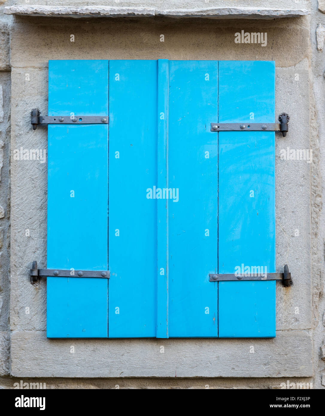 ein altes Fenster mit geschlossenen blauen Fensterläden aus Holz Stockfoto