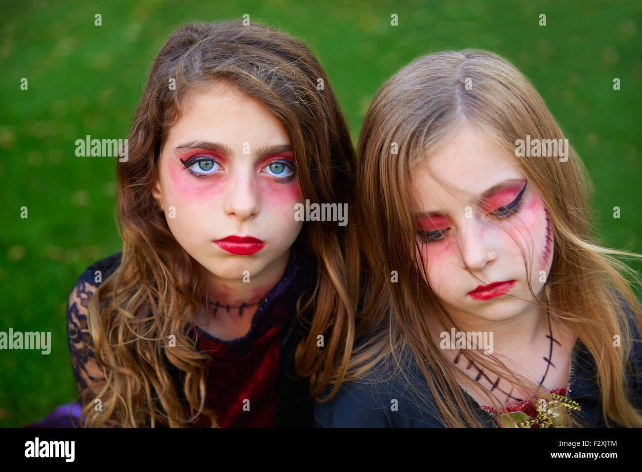 Halloween Make-up kleine Schwester Mädchen blaue Augen in Outdoor-Garten-Rasen Stockfoto