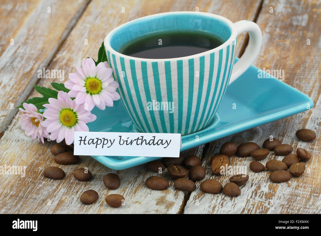 Alles Gute zum Geburtstagskarte mit Tasse Kaffee und rosa Gänseblümchen auf rustikalen Holzoberfläche Stockfoto