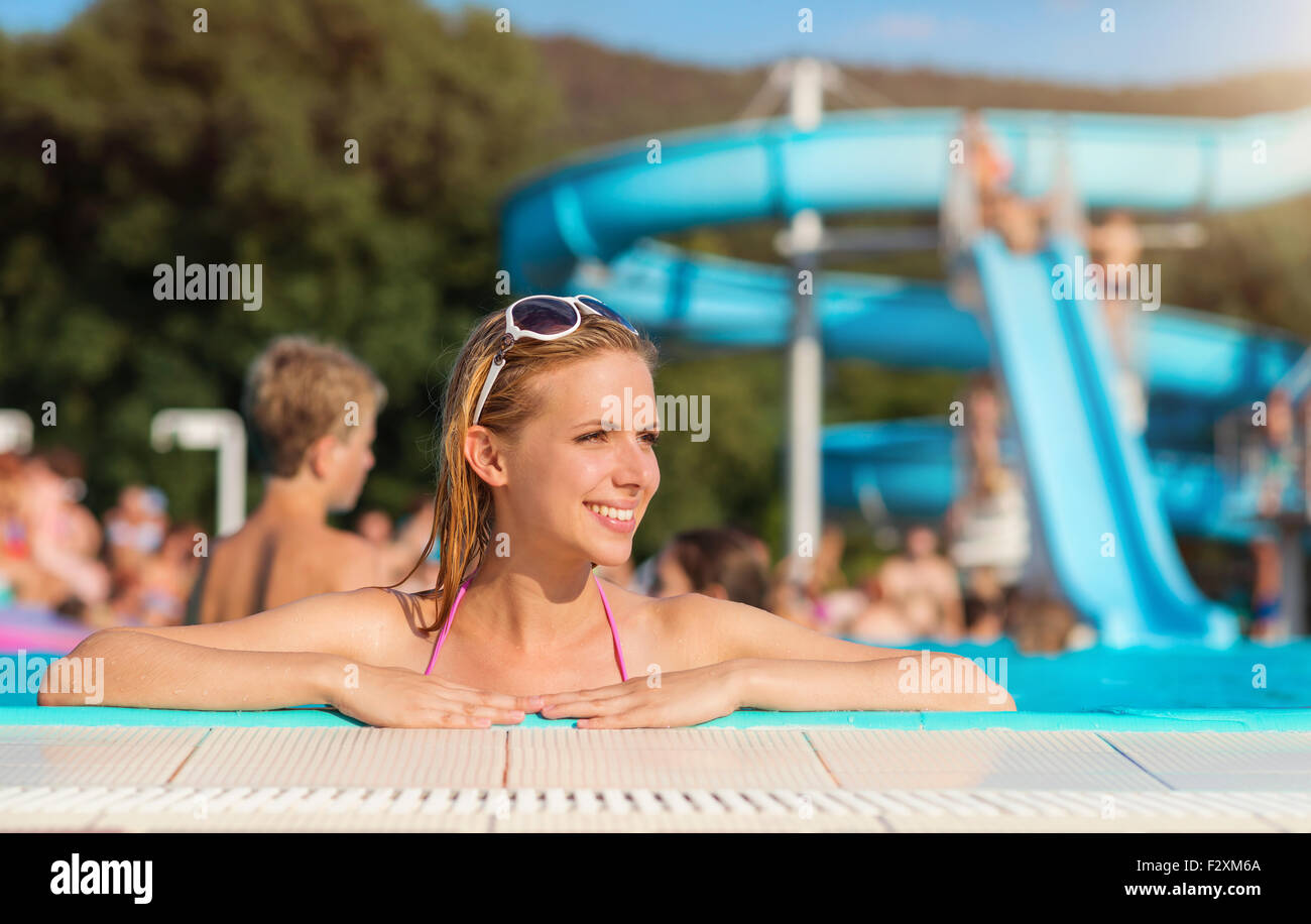 Schöne junge Frau, die Spaß außerhalb im Schwimmbad Stockfoto