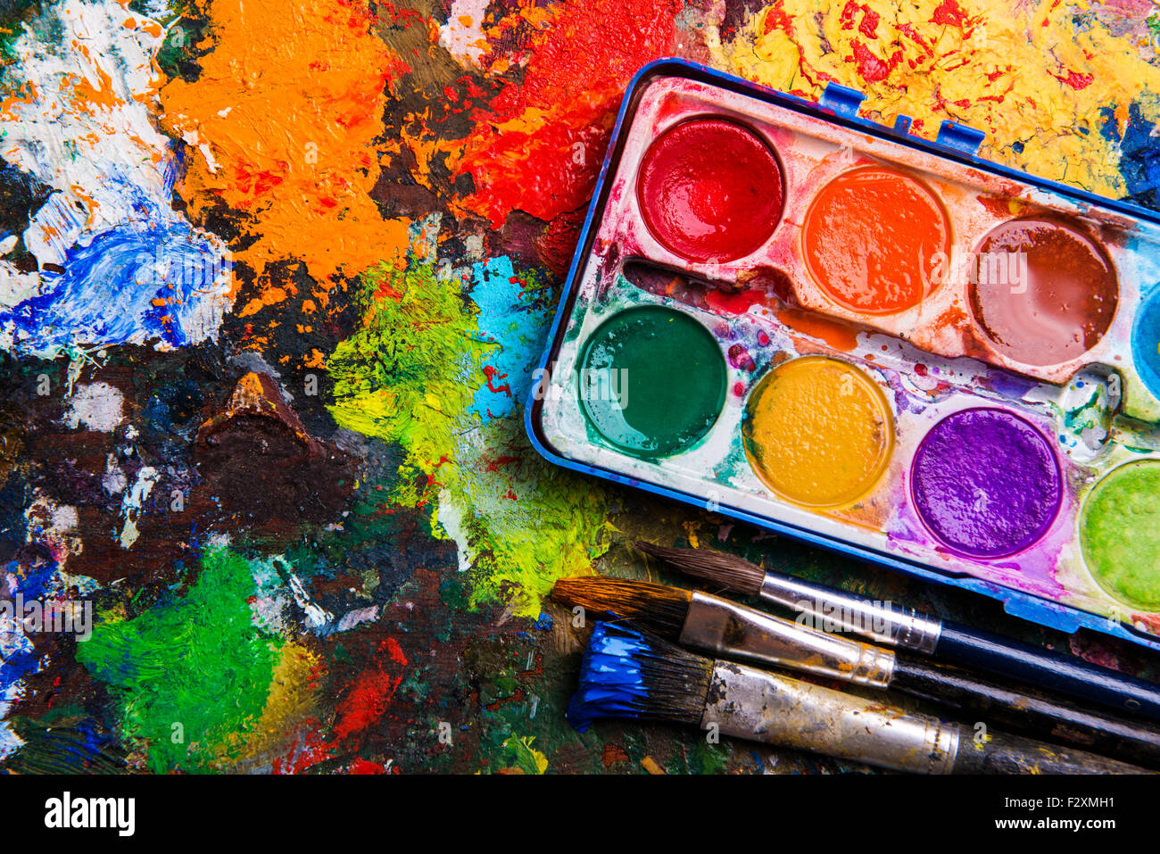 Schreibtisch des Künstlers mit Aquarellfarben und Pinsel. Stockfoto