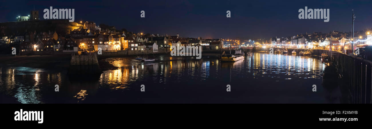 Bunte Lichter aus alten Whitby reflektiert im historischen Hafen, North Yorkshire Coast, England, UK Stockfoto